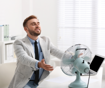 Suit wearer sits in front of fan