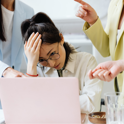 Une employée stressée devant son ordinateur portable, confrontée à des tâches floues et manquant de visibilité.